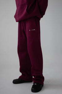 burgundy tracksuit with a logo on a grey background